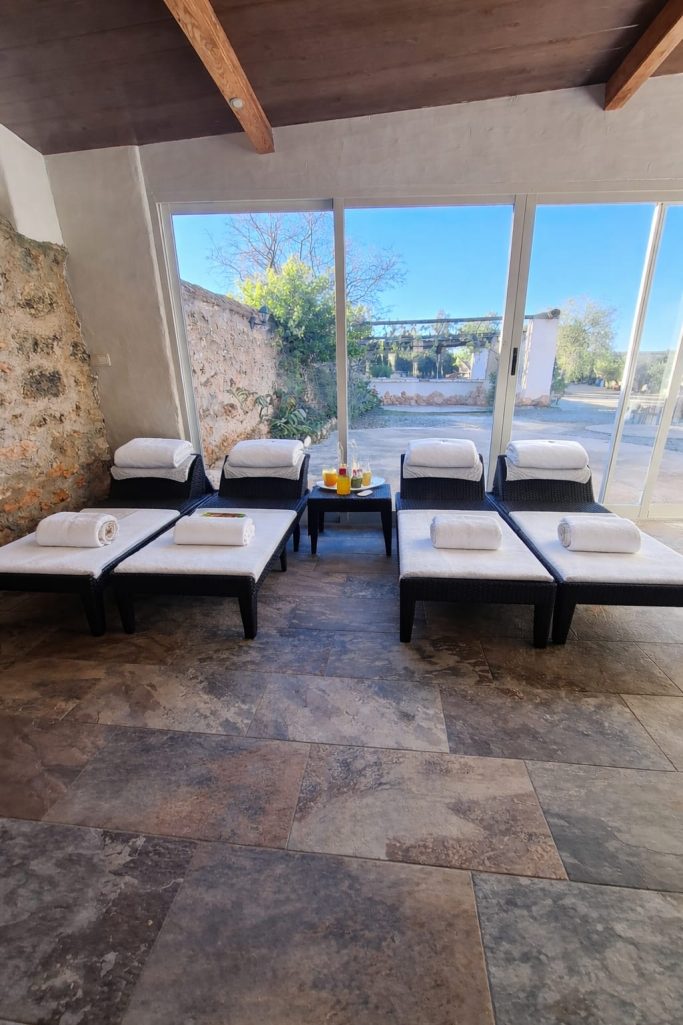 Sillas de spa alineadas junto a grandes ventanales con vistas al exterior.