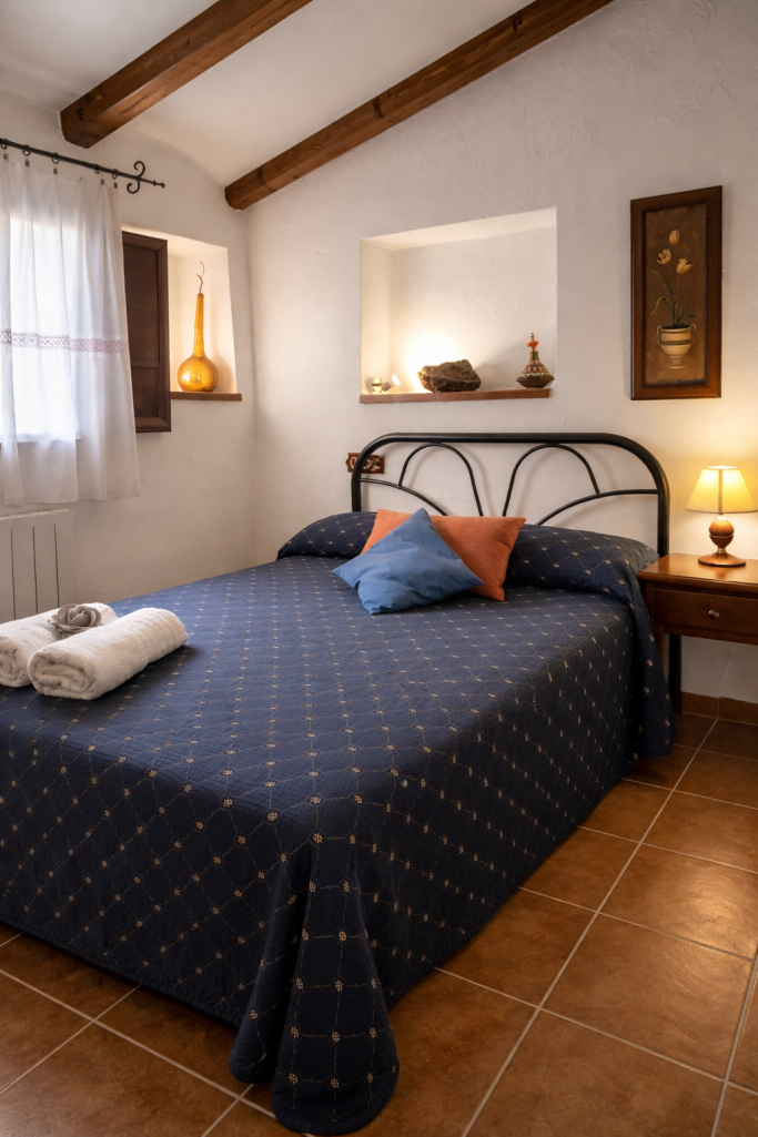 Habitación acogedora con cama, almohadas y decoración cálida en tonos neutros.