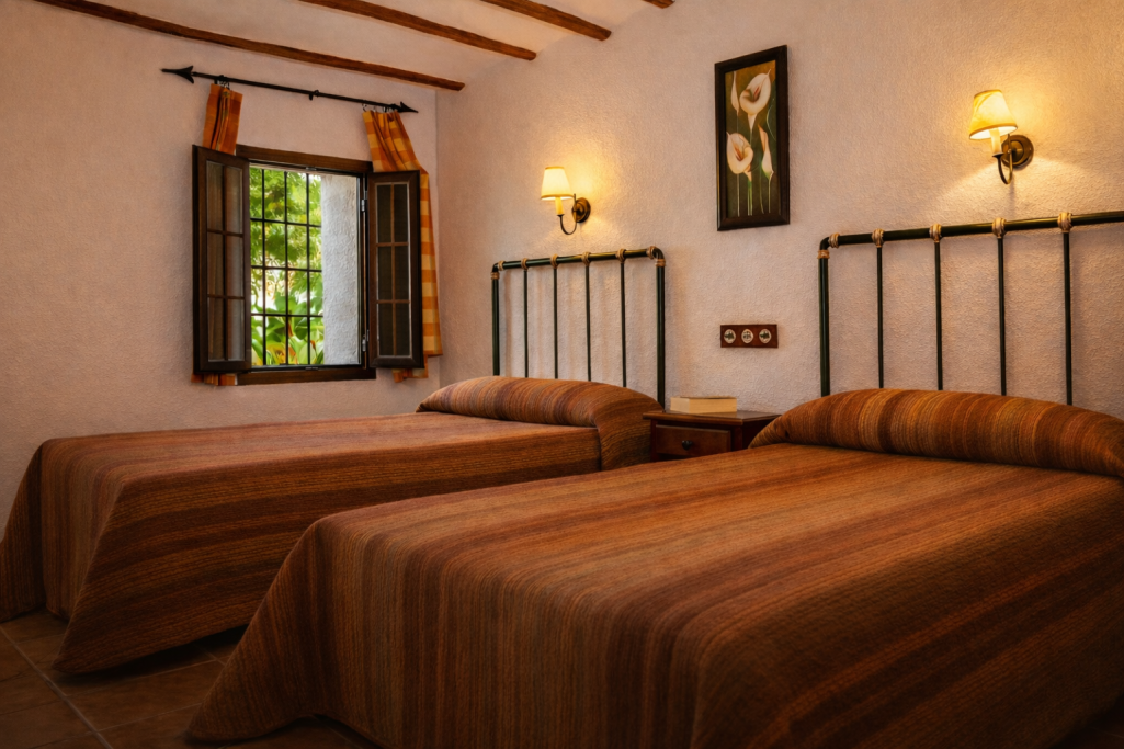 Habitación con dos camas individuales, paredes claras y decoración sencilla.