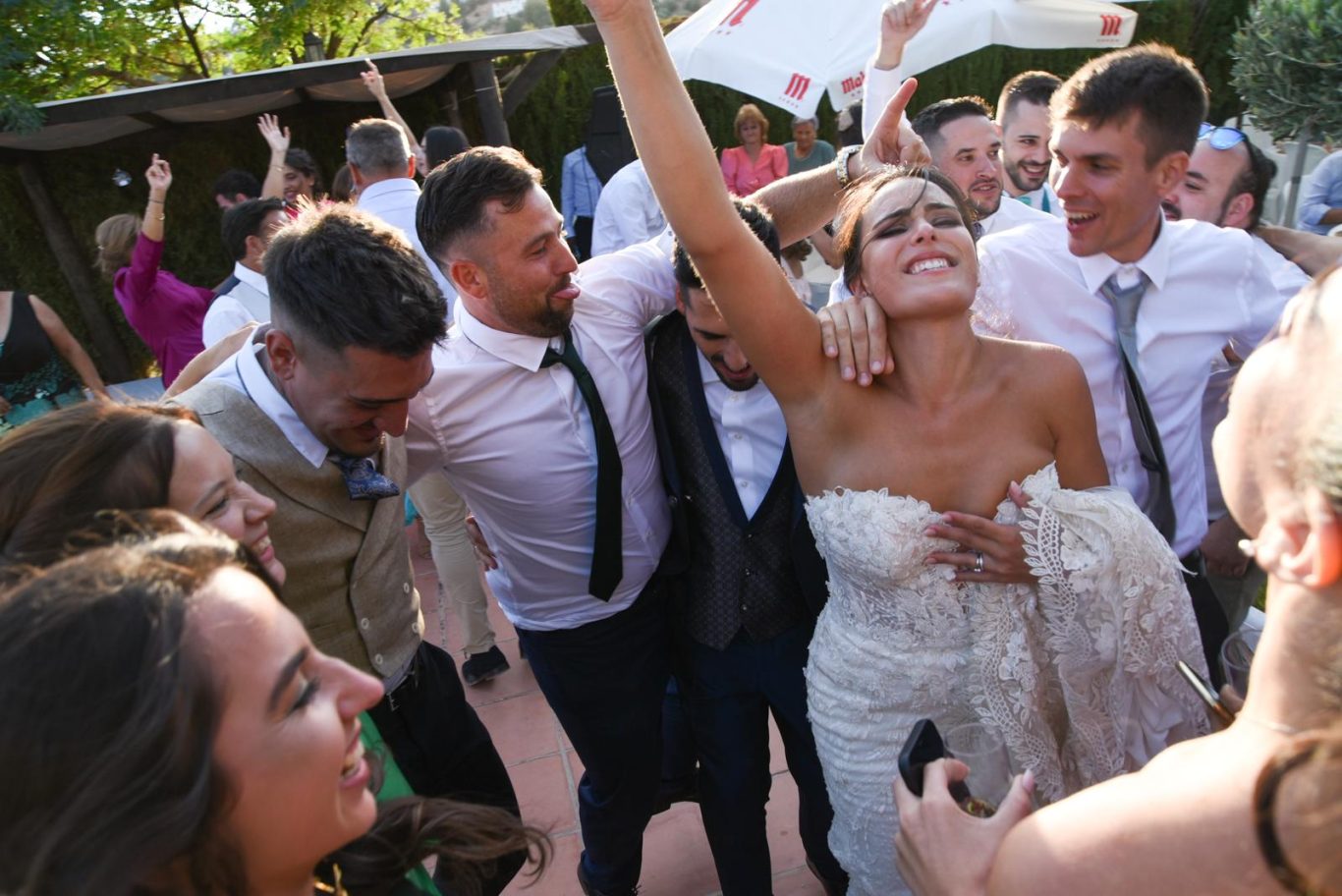 Bailarines celebrando con alegría en una recepción de boda al aire libre.