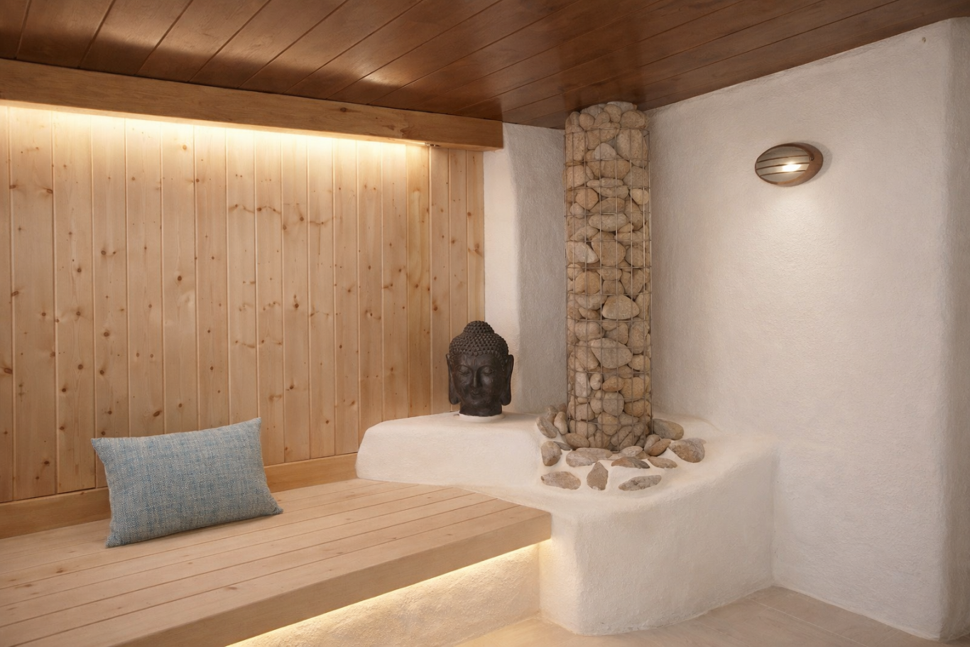 Sala de relajación con pared de madera, bancos de madera y una chimenea de piedras.