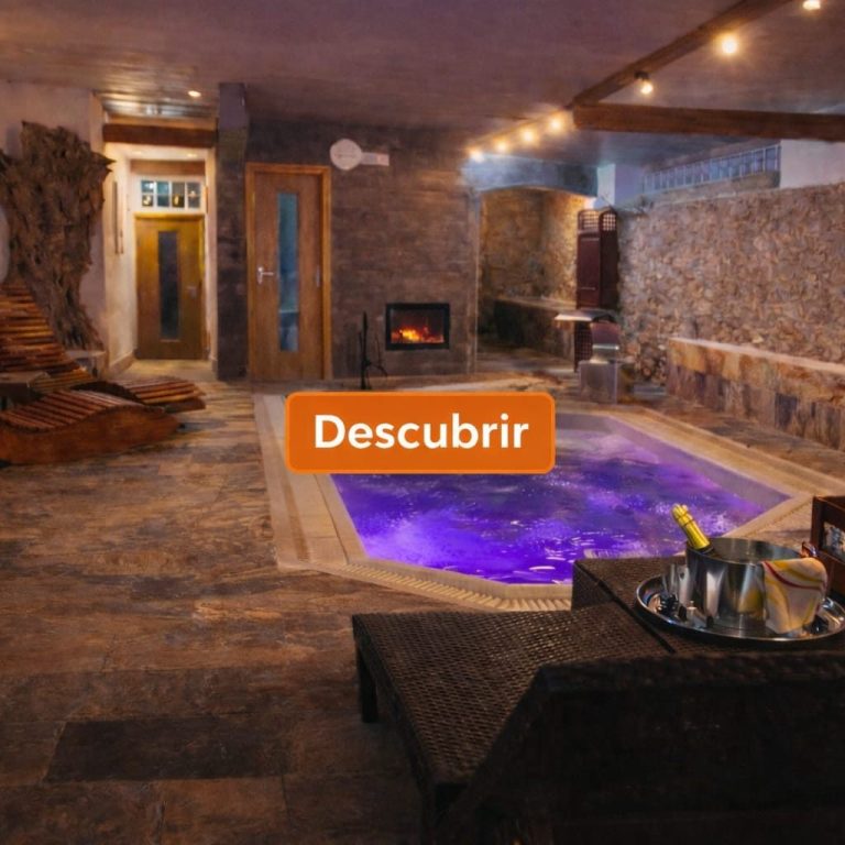 Cascada con agua fluyendo sobre rocas, rodeada de vegetación y luz suave.