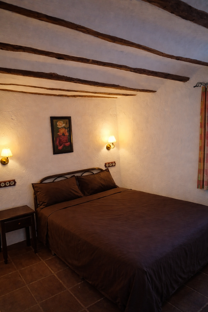 Habitación acogedora con cama grande y lámparas de pared. Decoración sencilla y cálida.